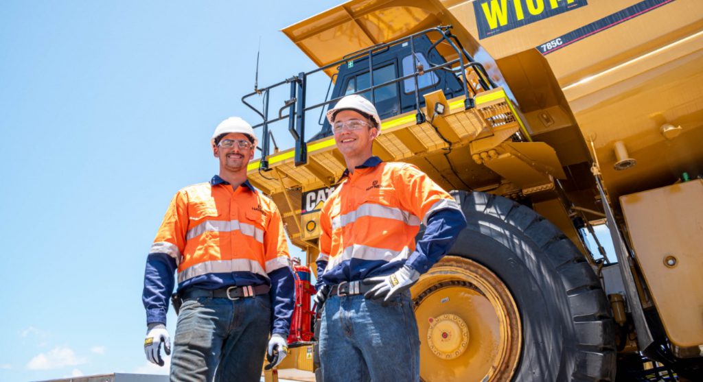 Mining workers standing in front of 785C CAT Truck
